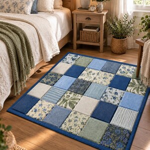 May include: A rectangular area rug featuring a patchwork design of square fabric tiles in various shades of blue, sage green, and cream. The pattern includes solid colors, delicate floral prints, and thin vertical stripes with a dark blue border.