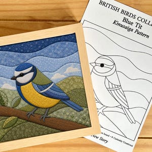 May include: A square framed Kinusaiga fabric art piece depicting a blue tit bird perched on a branch against a rolling green landscape and blue sky, accompanied by a printed paper pattern titled British Birds Collection Blue Tit.