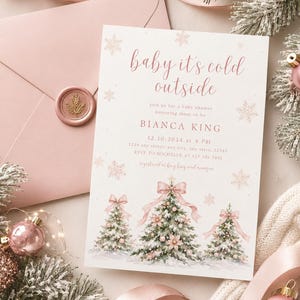 K&ouml;nnte beinhalten: Eine wei&szlig;e Babyparty-Einladungskarte mit rosafarbenem Text, der baby it's cold outside, Bianca King und Veranstaltungsdetails lautet. Die Karte zeigt Illustrationen von drei schneebedeckten Weihnachtsb&auml;umen mit rosa Schleifen und Schneeflocken.
