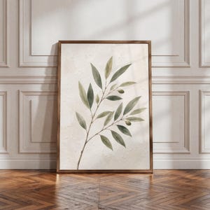 May include: A vertical rectangular wall art piece featuring a botanical illustration of an olive branch with green leaves and small olives. The artwork is set against a textured off-white background and is enclosed in a dark brown wooden frame.