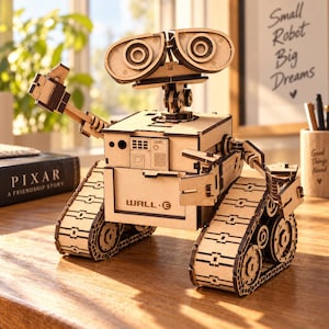 Könnte beinhalten: Ein hellbraunes Holzmodell des Roboters WALL-E mit zwei großen kreisförmigen Augen, einem kastenförmigen Rumpf mit der Aufschrift WALL-E und beweglichen Armen. Der Roboter steht auf zwei Kettenlaufwerken und zeigt detaillierte mechanische Paneele.