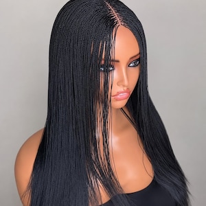 May include: A black braided wig featuring long, thin, micro-braids with a centre part. The hair is straight and falls past the shoulders. The wig is displayed on a mannequin head with a smooth, tan complexion, defined eyes, and glossy lips.