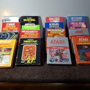 May include: A collection of vintage Atari 2600 video game cartridges in their original cardboard boxes. Titles include Breakout, Target Fun, Combat, Basketball, Surround, Air-Sea Battle, Space War, Bowling, Backgammon, Sky Diver, Circus Atari, and Star Raiders.