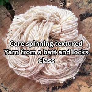 Op de afbeelding: Een close-up van wit garen gesponnen van een batt en lokken. Het garen is getextureerd en heeft een natuurlijke, rustieke uitstraling. Het garen ligt op een houten oppervlak. De tekst "Core spinning textured Yarn from a batt and locks Class" is zichtbaar in de afbeelding.