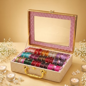 Puede incluir: Una caja de almacenamiento rectangular con marco dorado, tapa de cristal transparente y exterior beige texturizado. El interior está forrado con tela rosa y contiene varias filas de brazaletes finos y coloridos en tonos verde, rojo, azul y morado.
