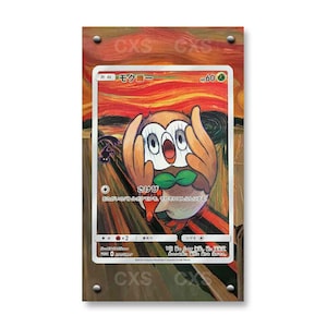 Könnte beinhalten: Eine rechteckige Sammelkarte mit einer Rowlet-Figur mit weit aufgerissenen Augen und an das Gesicht gehaltenen Flügeln, die das Gemälde Der Schrei nachahmt. Der Hintergrund zeigt wirbelnde orangefarbene und rote Pinselstriche. Japanischer Text und HP 60.