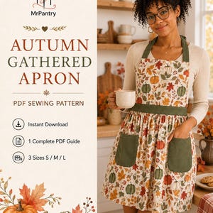 May include: A PDF sewing pattern for an autumn gathered apron by MrPantry. The apron features a cream background with a print of orange, green, and brown pumpkins and autumn leaves. It includes olive green straps, a waistband, and two pockets.