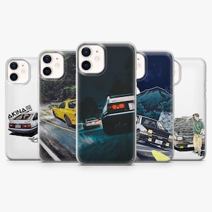 May include: Five clear smartphone cases featuring various illustrations of Japanese sports cars, including a yellow coupe on a mountain road, a white hatchback drifting at night, and a person standing next to a car with an open hood.