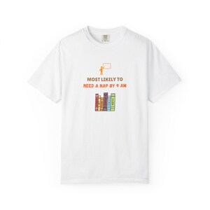 May include: A white short-sleeve t-shirt featuring an orange graphic of a teacher at a whiteboard above the brown text MOST LIKELY TO NEED A NAP BY 9 AM and a row of colorful books labeled Geometry, Art, History, Literature, Science, and Math.