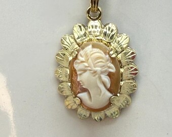 Mid-century shell cameo pendant set in an ornate scalloped gold frame