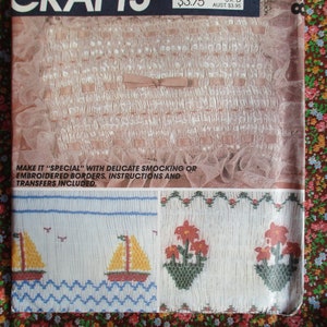 May include: A vintage crafts magazine cover featuring instructions for making smocked or embroidered borders. The cover shows a white fabric with a delicate smocked design, and two smaller images of embroidered borders with a sailboat and floral motifs.