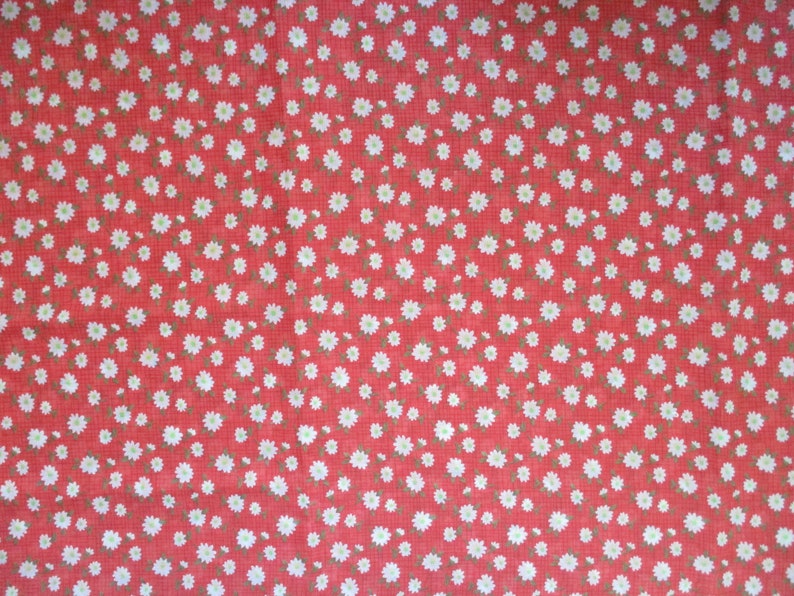 K&ouml;nnte beinhalten: Roter Stoff mit einem wei&szlig;en G&auml;nsebl&uuml;mchen-Druck. Der Stoff ist einfarbig rot mit kleinen wei&szlig;en G&auml;nsebl&uuml;mchen, die &uuml;ber den Stoff verteilt sind.