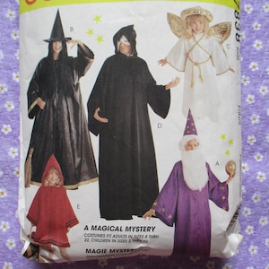 Peut inclure: Un patron de couture pour des costumes d'Halloween, avec une sorcière, une figure encapuchonnée, un ange et un magicien. Les costumes sont en noir, blanc, rouge et violet. Le texte indique "A MAGICAL MYSTERY" et "COSTUMES FIT ADULTS IN SIZES 8 THRU 22, CHILDREN IN SIZES 2 THRU 12."