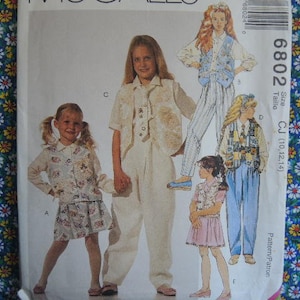 Peut inclure: Un patron de couture pour vêtements d'enfants, présentant quatre modèles différents. Le patron est pour les tailles 10, 12 et 14. Le numéro du patron est 6802.