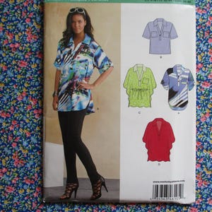 Pode incluir: Um padrão de costura com cinco designs de camisas diferentes. O padrão inclui uma mulher vestindo uma camisa com estampa azul e branca com colarinho branco e mangas compridas. Os outros designs incluem uma camisa azul com colarinho branco e mangas curtas, uma camisa verde com colarinho branco e mangas curtas, uma camisa vermelha com colarinho branco e mangas curtas e uma camisa listrada azul e branca com colarinho branco e mangas curtas. O padrão é impresso em um fundo branco com texto preto.