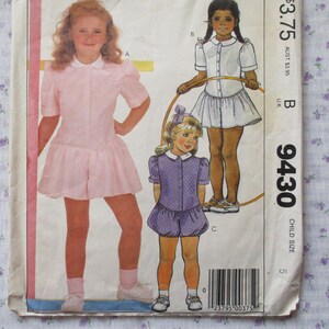 Pode incluir: Um padrão de costura para roupas infantis. O padrão inclui três estilos diferentes de vestidos, todos com gola Peter Pan. O padrão é para os tamanhos 5-14. O número do padrão é 9430.