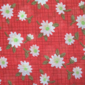 K&ouml;nnte beinhalten: Roter Stoff mit einem wei&szlig;en Blumenmuster. Der Stoff hat ein Gittermuster und ist mit kleinen wei&szlig;en Bl&uuml;ten mit gr&uuml;nen Zentren bedeckt.