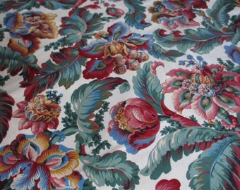 Könnte beinhalten: Ein weißer Stoff mit einem floralen Muster. Die Blumen sind rot, rosa, blau und gelb. Die Blätter sind grün.