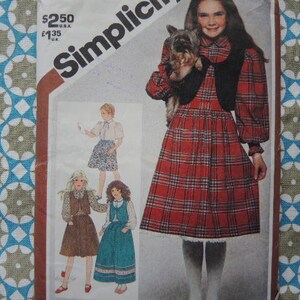 May include: A sewing pattern for a plaid dress with a vest and a ruffled skirt. The pattern includes instructions for making a dress with a long sleeve and a short sleeve. The pattern also includes instructions for making a skirt with a ruffle. The pattern is for sizes 6-14.