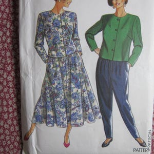 以下が含まれることがあります： 2種類の衣服のオプションが描かれた裁縫パターンの封筒。1つは青と紫のペイズリー柄の長袖ジャケットとスカートのセット。もう1つは、無地の緑色の長袖ジャケットと紺色のズボンの組み合わせです。