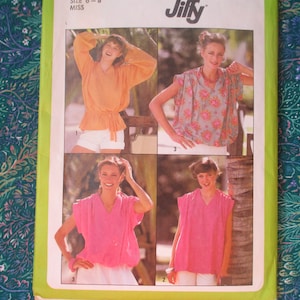 May include: A sewing pattern for four different tops. The pattern is for sizes 8-18 and is from the Jiffy brand. The tops are all sleeveless and have a V-neck. The first top is a light orange color, the second is a pink floral print, the third is a solid pink, and the fourth is a solid light blue.