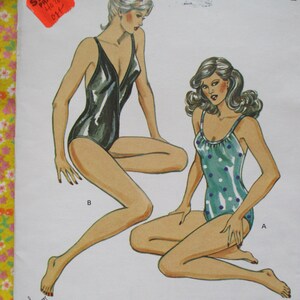 May include: Two women modeling swimsuit designs. One woman is wearing a black swimsuit with a plunging neckline. The other woman is wearing a green and white polka dot swimsuit with a scoop neckline. Both swimsuits have a retro style.