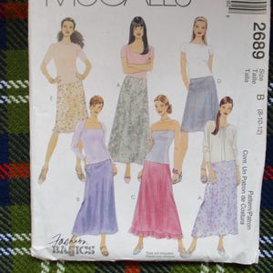 Puede incluir: Un patrón de costura vintage con ilustraciones de faldas y tops para mujer. El patrón incluye varios estilos, con la talla B para las tallas 8-12. El patrón está etiquetado como "Fashion Basics" e incluye el número 2689.