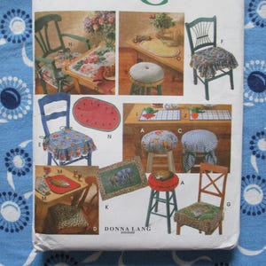 May include: A vintage sewing pattern featuring various chair cushions and seat covers. The designs include floral, gingham, and animal print patterns. The pattern also shows a watermelon-shaped seat cushion.