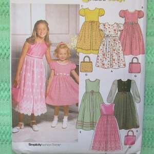 Könnte beinhalten: Ein Schnittmuster für Mädchenkleider. Das Muster enthält fünf verschiedene Kleidstyles, darunter ein Gingham-Kleid, ein Blumenkleid, ein gelbes Kleid, ein grünes Kleid und ein rosa Kleid. Das Muster enthält auch Anleitungen zum Nähen von passenden Handtaschen.