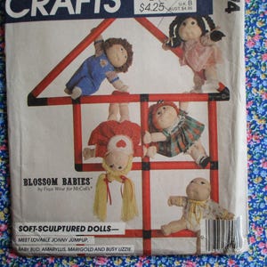 Puede incluir: Un patrón de costura vintage para hacer muñecas de tela esculpidas. El patrón presenta un esquema de color rojo, blanco y azul e incluye instrucciones para hacer cinco muñecas: Jonny Jumpup, Baby Bud, Amaryllis, Marigold y Busy Lizzie.