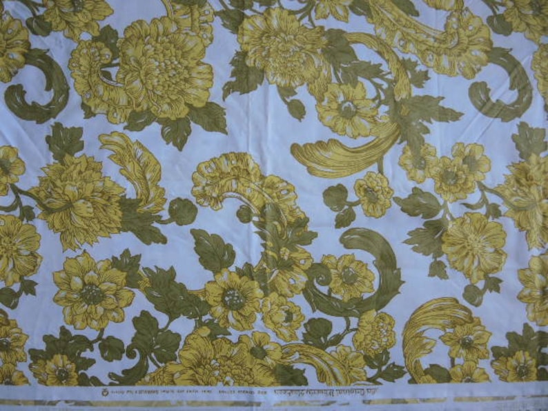 May include: White fabric with a repeating pattern of yellow floral designs. The floral pattern features stylized leaves and flowers with a vintage aesthetic.