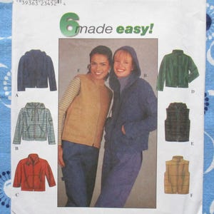 May include: A sewing pattern featuring six jacket and vest designs. The jackets include a navy blue zip-up jacket, a green plaid hooded jacket, and a red jacket. The vests include a brown vest and a tan plaid vest. The text "6 made easy!" is at the top.