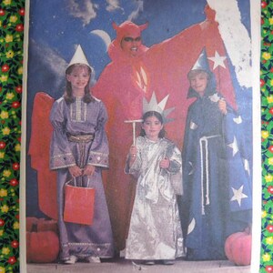 May include: A group of four children dressed in costumes for Halloween. The children are dressed as a devil, a fairy, a princess, and a wizard. The devil is wearing a red costume with horns and a tail. The fairy is wearing a purple dress with wings. The princess is wearing a silver dress with a crown. The wizard is wearing a blue robe with a hat and a wand.