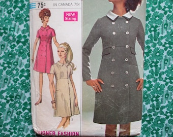 May include: Vintage sewing pattern featuring illustrations of dresses. The pattern includes a double-breasted gray coat dress with a white collar, and two other dress designs in pink and beige. The background is a green floral pattern.