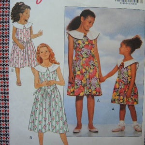 May include: A sewing pattern for girls' dresses. The pattern includes three different styles: a short-sleeved dress with a large collar, a sleeveless dress with a large collar, and a sleeveless dress with a smaller collar. The dresses are all floral patterned.