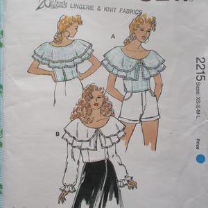 May include: A sewing pattern for a ruffled blouse with a Peter Pan collar. The pattern includes three different views, each with a different style of ruffle. The pattern is for sizes XS-S-M-L.