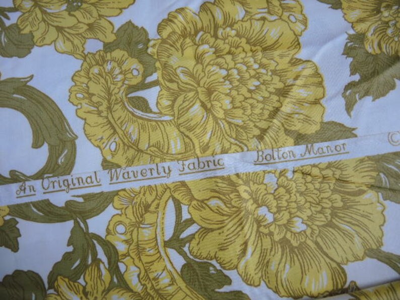 May include: A white fabric with a yellow floral pattern. The fabric has a label that reads "An Original Waverly Fabric Bolton Manor".