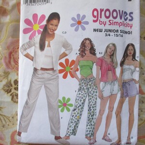 May include: A sewing pattern for girls' clothing, featuring four different styles of pants and tops. The pattern is called "Grooves by Simplicity" and is for sizes 3/4 to 15/16.