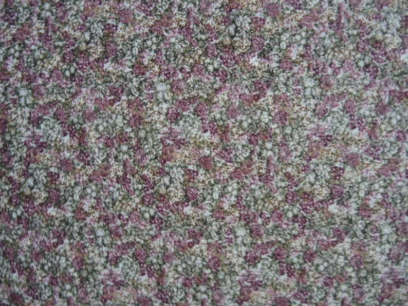 May include: A close-up of a fabric with a small-scale floral pattern. The fabric is a mix of white, pink, and green.
