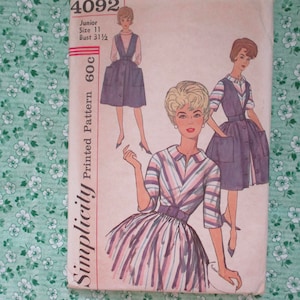 May include: Simplicity Printed Pattern 60C, a vintage sewing pattern for a junior size 11 dress with a bust measurement of 31 1/2 inches. The pattern features two different dress styles, one with a striped bodice and a full skirt, and the other with a sleeveless bodice and a shorter skirt. The pattern is illustrated with three women wearing the dresses.