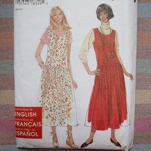 Puede incluir: Un patrón de costura con dos mujeres que llevan diferentes estilos de vestidos. El vestido de la izquierda es de estampado floral con un corpiño sin mangas y una falda fruncida. El vestido de la derecha es de color rojo sólido con un corpiño sin mangas y una falda fruncida. El patrón incluye instrucciones en inglés, francés y español.