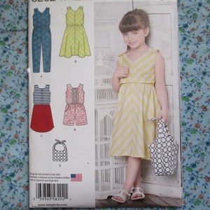 Könnte beinhalten: Ein Schnittmuster für ein Mädchenkleid und einen Mädchen-Jumpsuit. Das Muster umfasst fünf verschiedene Stile, darunter ein gelbes und weiß gestreiftes Kleid, ein rot und weiß gestreiftes Kleid, einen Jumpsuit mit Blumenmuster, einen einfarbigen blauen Jumpsuit und eine Lätzchen. Das Muster wurde in den USA entworfen und gedruckt.