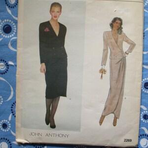 May include: Vintage sewing pattern featuring two women's suit designs. One suit is a black skirt suit with a V-neck jacket. The other is a light-colored suit with a long skirt and a wrap-style jacket. The pattern is labeled "JOHN ANTHONY" and has the number "2269".