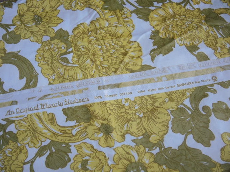 May include: A white fabric with a yellow floral pattern. The fabric has a label that reads "An Original Waverly Slesheen 100% Combed Cotton Color styled with Du Pont SAVALLUX Test Colors".