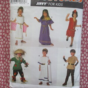 May include: A sewing pattern envelope for children's costumes titled JIFFY FOR KIDS. The front displays six illustrations of children wearing various outfits, including a white tunic, a purple dress, a red dress, a scarecrow, a toga, and a tunic.