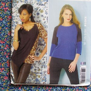 Puede incluir: Dos patrones de costura para mujeres para blusas. El patrón de la izquierda es para una blusa marrón con un detalle de estampado de leopardo. El patrón de la derecha es para una blusa azul con mangas negras. Los números de patrón son K4014 y XS-S-M-L-XL.