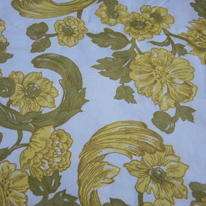 May include: A white fabric with a repeating pattern of yellow flowers and stylized leaves. The flowers are in various sizes and shapes, with some having a more detailed design than others.