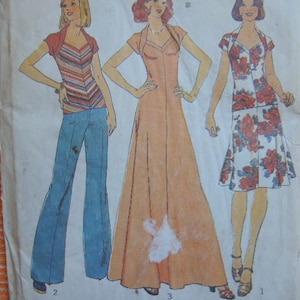May include: A vintage sewing pattern featuring three different styles of dresses. The first dress is a striped top with a V-neck and a pair of wide-legged pants. The second dress is a long, flowing dress with a V-neck and a fitted bodice. The third dress is a shorter, A-line dress with a floral print and a V-neck.