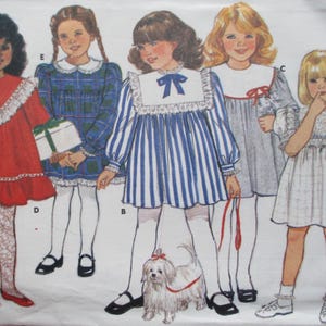 Puede incluir: Ilustración de cinco niñas con vestidos vintage. Los vestidos varían en estilo y color, incluyendo rojo, cuadros azules y rayas azules y blancas. Una niña sostiene un regalo, y otra tiene un perro blanco pequeño con correa. La imagen es un patrón de costura vintage.