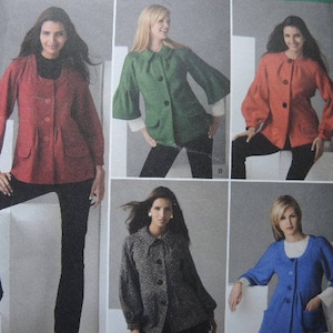 May include: Five women wearing different colored jackets. The jackets are all long-sleeved and have a button-up closure. The women are standing in front of a white background.